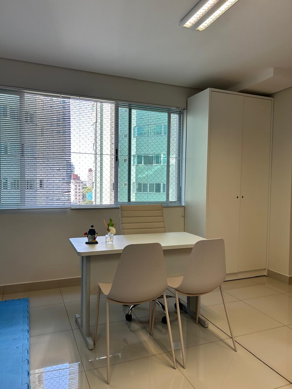 Sala de atendimento com mesa e cadeiras para avaliação clínica