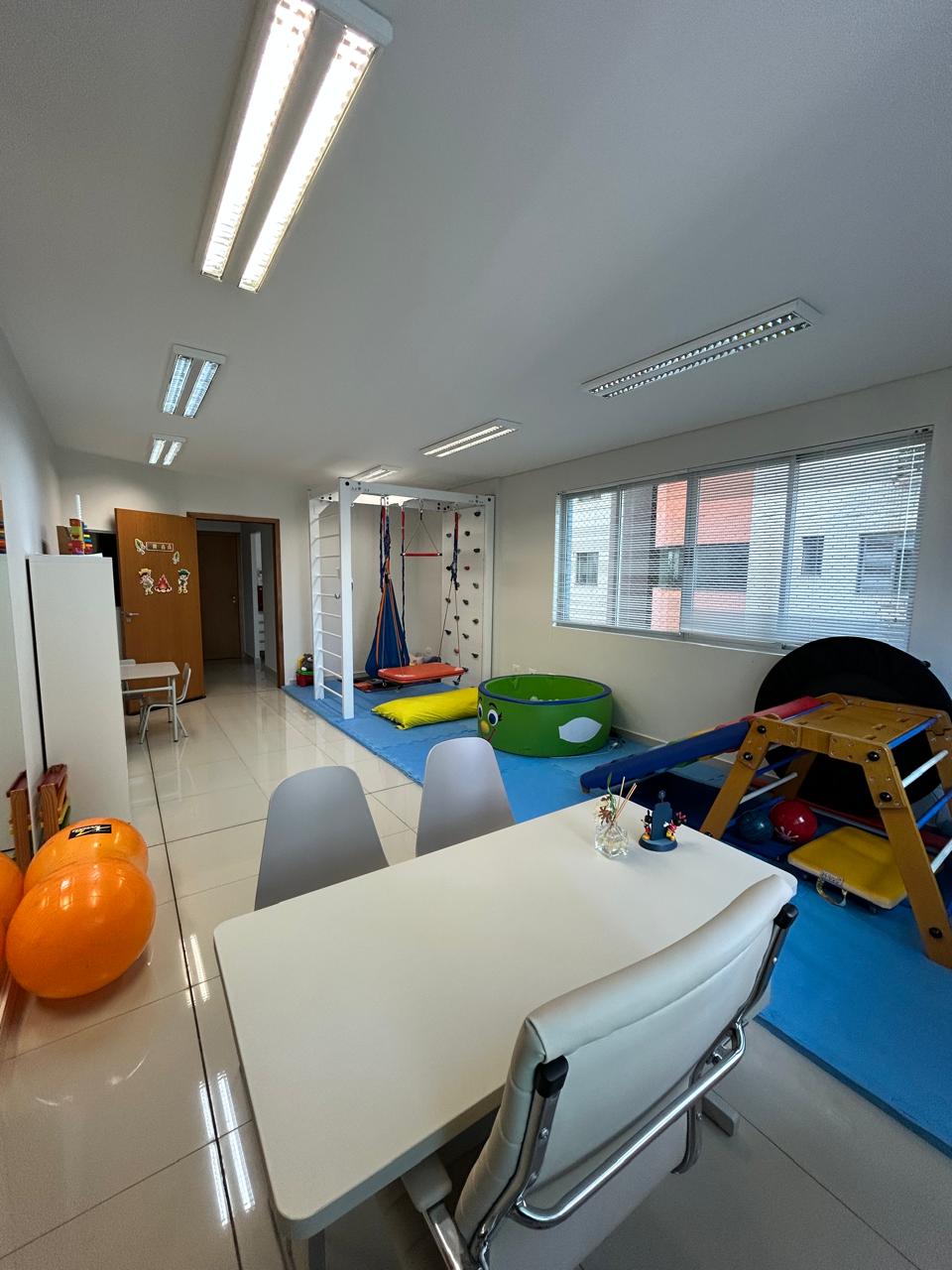 Sala de integração sensorial com escalada, balanços e piscina de bolinhas